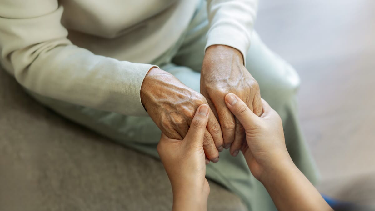 Caregiver holding hands with an older family member